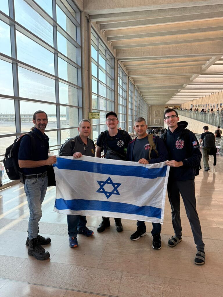 Members of Ner Tamid stand at Ben Gurion Airport in Israel; two of the firefighters volunteered in Israel for two weeks (Courtesy)