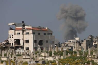 Smoke billows behind a cemetery (foreground) during Israeli strikes west of Gaza City on March 18, 2025.