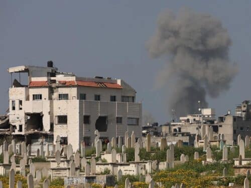 Smoke billows behind a cemetery (foreground) during Israeli strikes west of Gaza City on March 18, 2025.