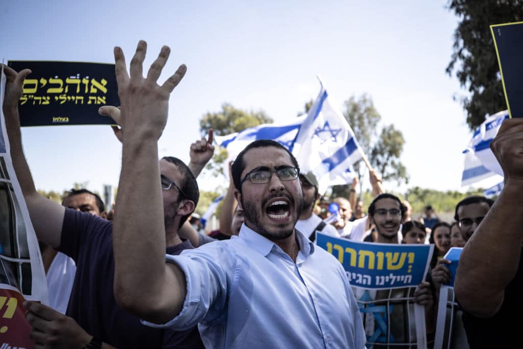 Far-right Israelis and relatives of the soldiers gather in front of the military court building and stage a protest against the arrest of nine soldiers accused of sexually abusing a Palestinian detainee at Sde Teiman Prison in the Negev desert, in Netanya, Israel on July 30, 2024. (Photo by Mostafa Alkharouf/Anadolu via Getty Images)