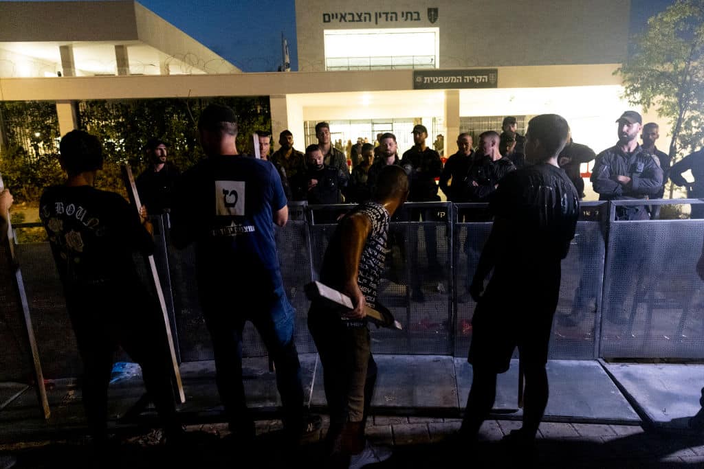 Protesters knock  a stick on barriers during a demonstration against Israeli military prosecutors  near a military court  on July 30, 2024 in Kfar Yona, Israel.