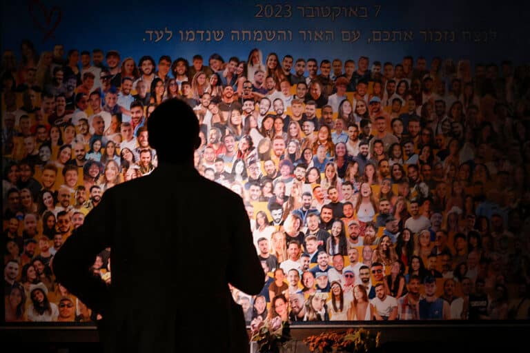 A person views a collage as relatives and supporters of Israeli hostages, taken by Palestinian militants during the October 7 Hamas attack, attend the Nova memorial near Kibbutz Reim in southern Israel, the site of the Nova music festival attacked by militants, during the first anniversary of the attacks on October 7, 2024. (Photo by John Wessels / AFP) (Photo by JOHN WESSELS/AFP via Getty Images)