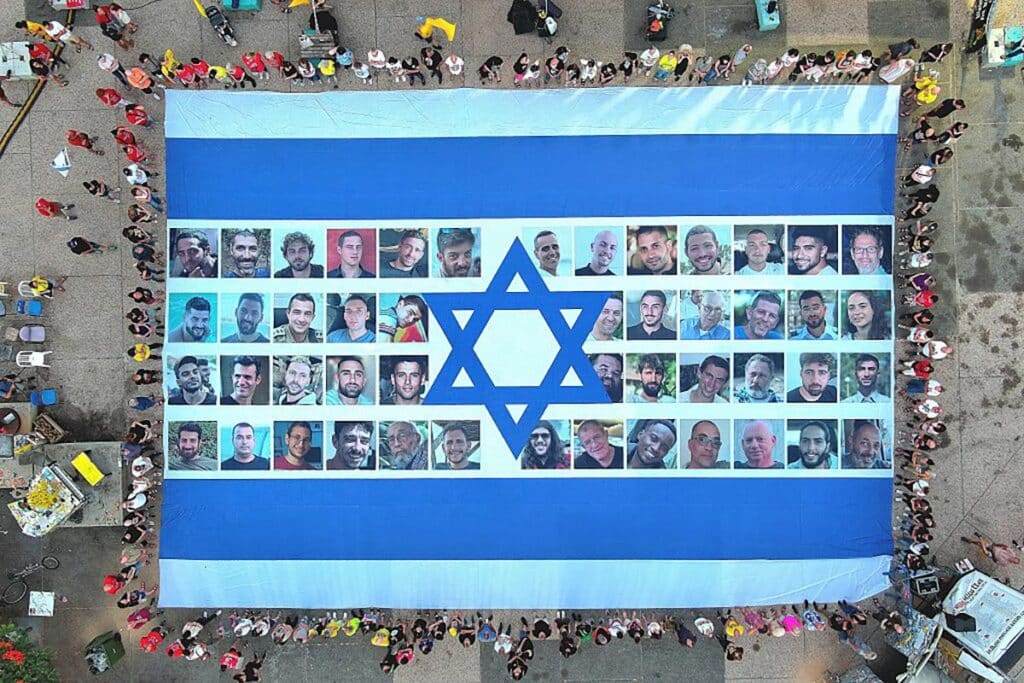 Protesters gather in Hostage Square and hold a giant Israeli flag with photos of hostages on it, demanding the return of the hostages held in Gaza, as protests and strikes continue in Tel Aviv, Israel on August 17, 2025.