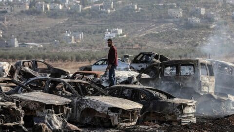 A Palestinian checks a vehicle scrapyard after Israeli settlers burned it in the town of Huwara, south of the West Bank city of Nablus, on Nov. 21, 2025. According to the official WAFA news agency, Israeli settlers set fire to a vehicle scrapyard here on Friday evening. (Photo by Ayman Nobani/Xinhua via Getty Images)