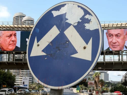 A road sign stands in front of a large billboard featuring Israel's Prime Minister Benjamin Netanyahu (R) of the Likud party and former military chief and leader of the centrist Yashar party, Gadi Eisenkot, in Ramat Gan on October 20, 2026. Israel heads to the polls on October 27 in its first election since the October 7, 2023, Hamas-led attack, in what is seen as a referendum on the prime minister. (Photo by Jack GUEZ / AFP via Getty Images)