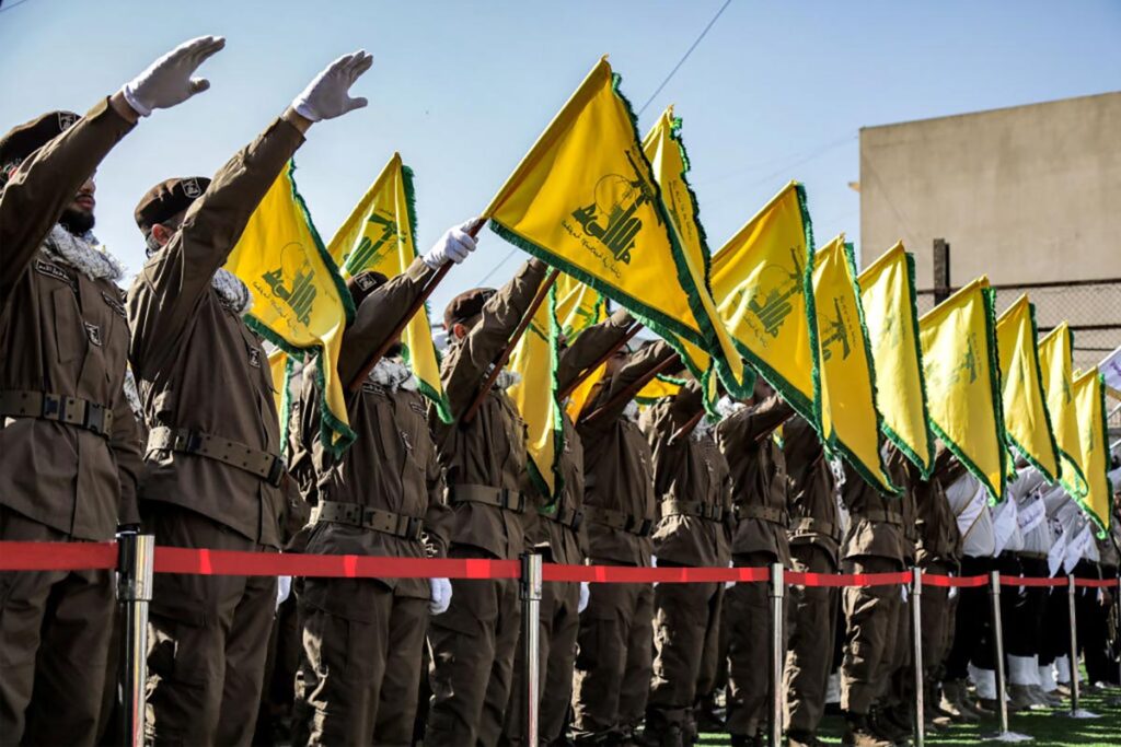 Hezbollah members salute and raise the group's yellow flags during the funeral of their fallen comrades Ismail Baz and Mohamad Hussein Shohury, who were killed in an Israeli strike on their vehicles, in Shehabiya in south Lebanon on April 17, 2024.