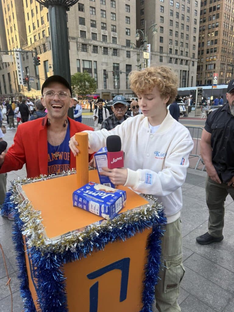 Kosha Dillz sets up the Knicks dreidel with social media star, actor and skateboarder Kayo Martin (courtesy)