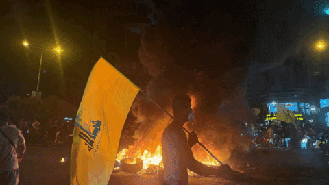Supporters of Lebanon's Hezbollah terrorist group block the streets with burning tires as they rally in cars and motorbikes to protest the government's endorsement of a plan to disarm it, in Beirut's southern suburbs early on August 8, 2025
