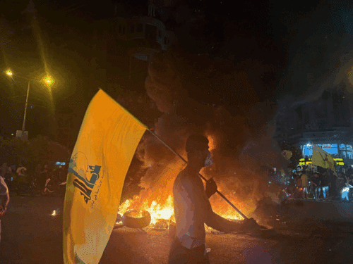Supporters of Lebanon's Hezbollah terrorist group block the streets with burning tires as they rally in cars and motorbikes to protest the government's endorsement of a plan to disarm it, in Beirut's southern suburbs early on August 8, 2025