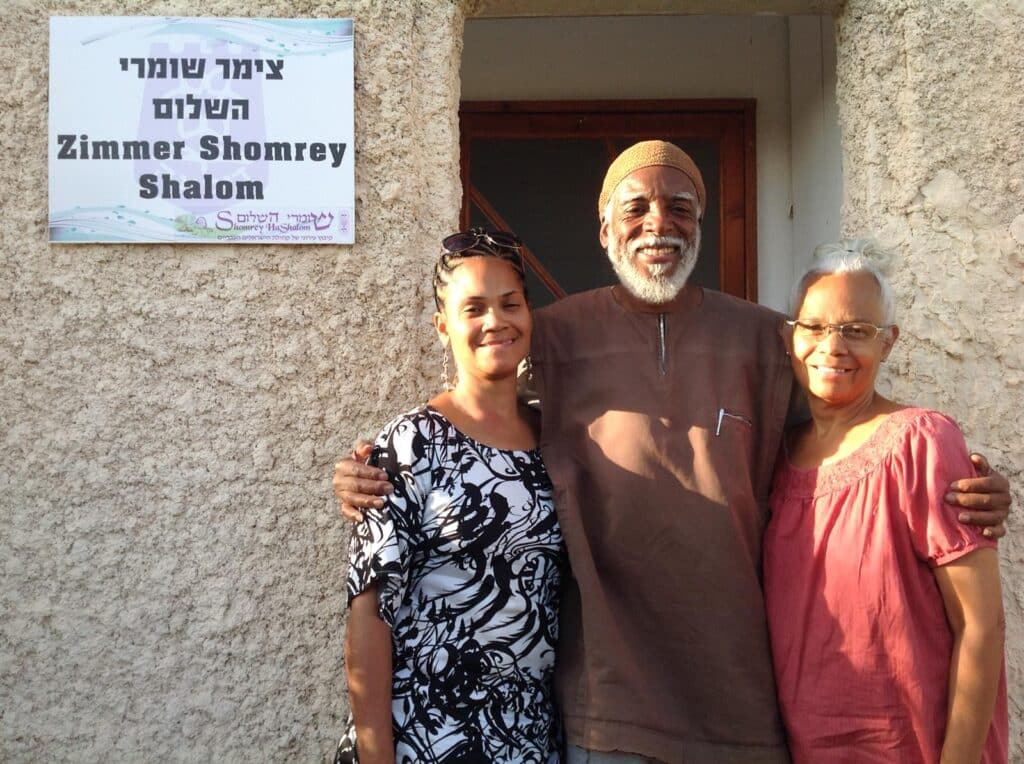Hebrew Israelite community members, from left, Yesha, Rofeh Ahmadeeyah and Ahmahlyah in front of the village’s bed-and-breakfast. Photo by Matthew Allen
